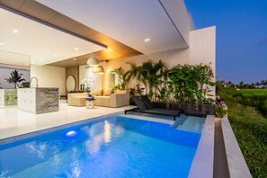 Una piscina al aire libre, tumbonas