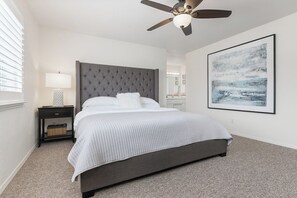 A bedroom with a bed, a nightstand, a ceiling fan, a wall-mounted artwork, and a window with blinds. - The Salty Escape at Dunes w/ firepit & beach toys (Oceano)