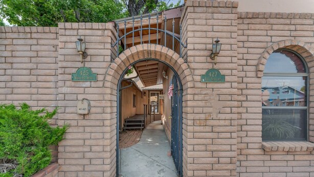 A brick building with an arched entrance, a small porch, and a window with a view. - A gem Right on Historic RTE 66 with outdoor space.  Walk to the action! (Williams)