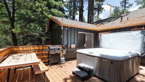 Een hottub, een houten terras en een barbecueplaats.