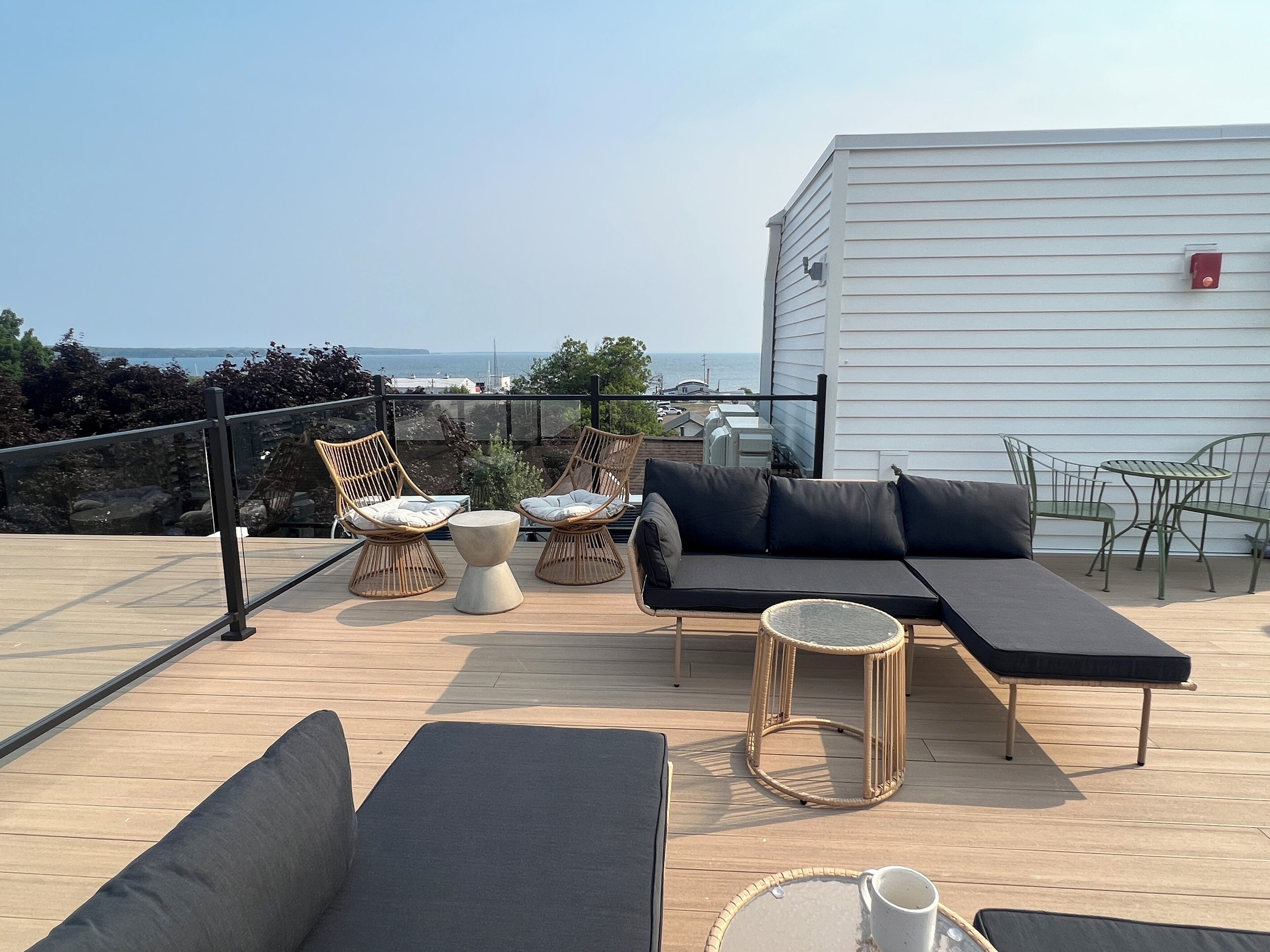 A rooftop terrace with a sofa, chairs, and a table.