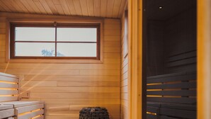 A sauna room with wooden benches and a large window. - St. James Social (Bayfield)