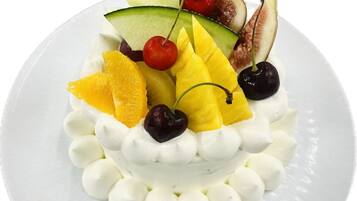 A dessert with fruit and cream on a white plate.