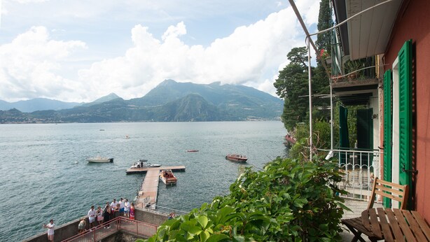 A lakeside view with boats, a dock, and a mountainous backdrop. - Casa Margherita in Varenna (Varenna)