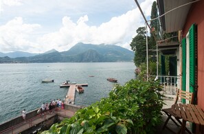 A lakeside view with boats, a dock, and a mountainous backdrop. - Casa Margherita in Varenna (Varenna)