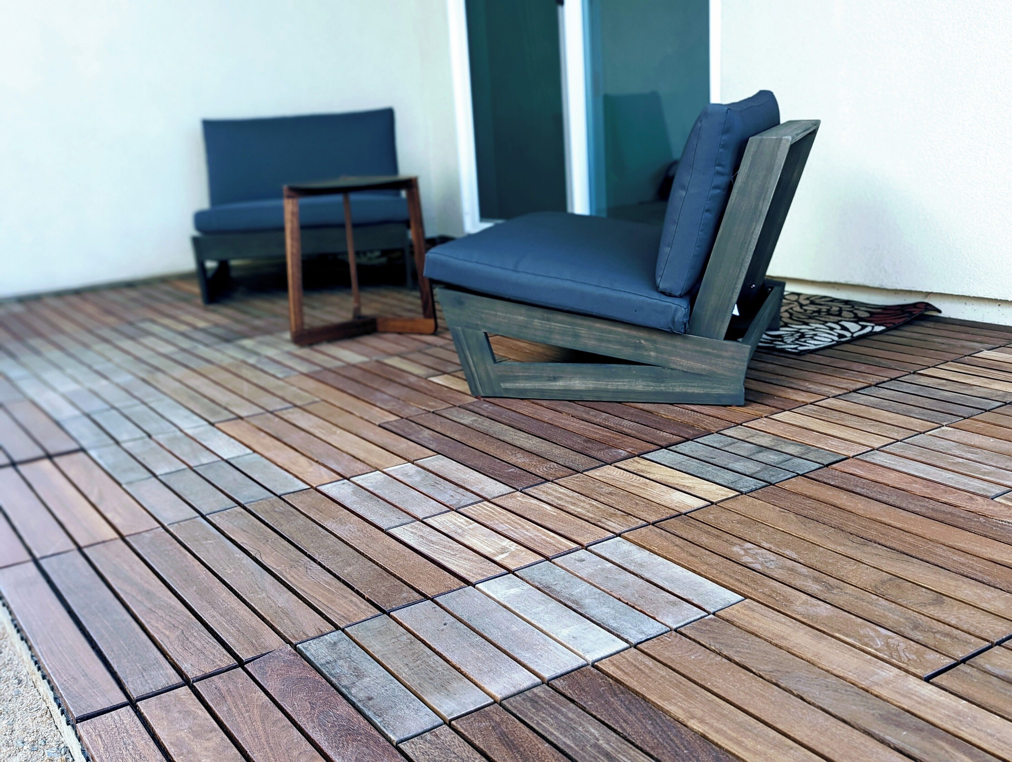 A wooden deck with a blue chair and a small table.