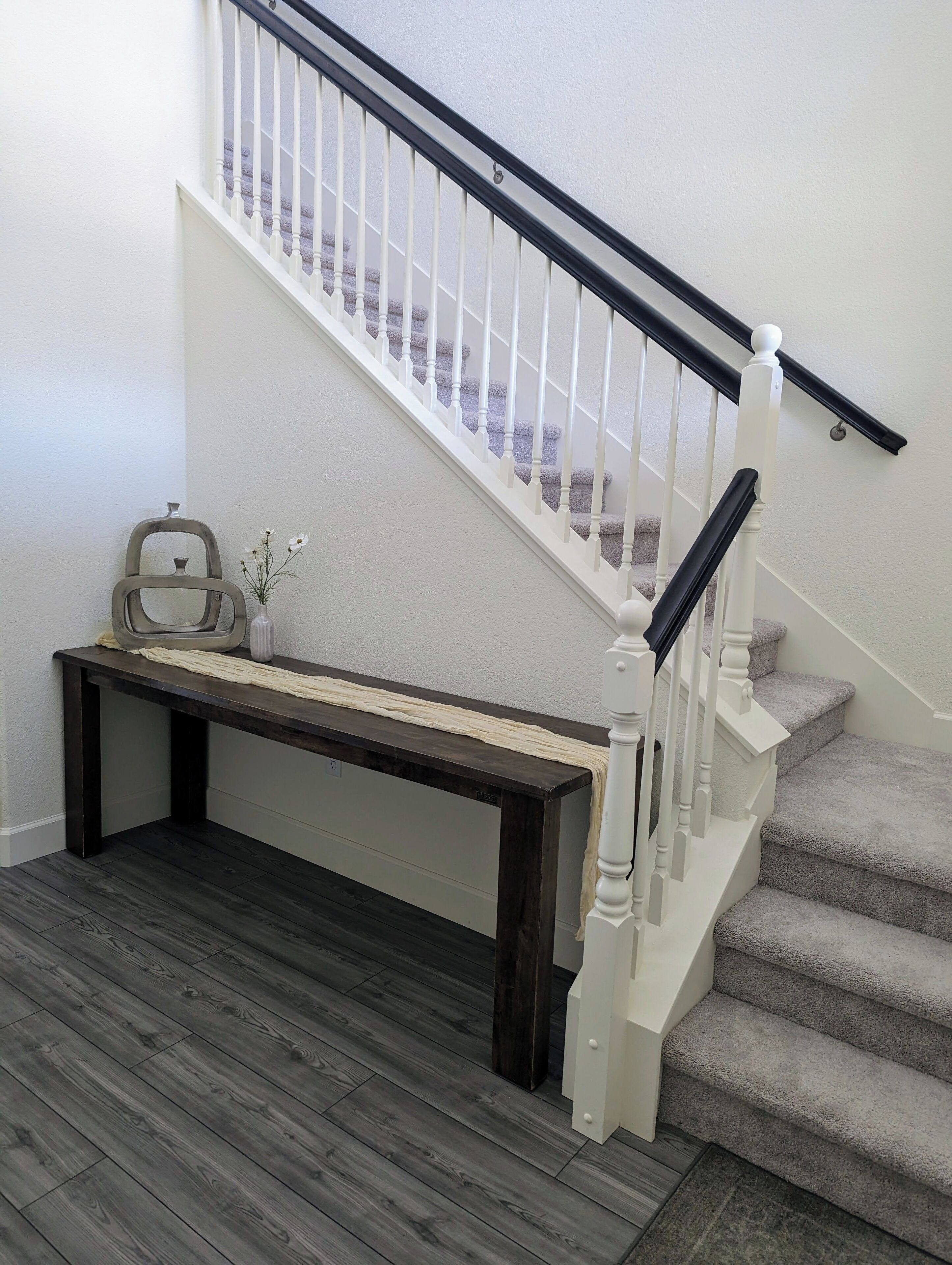 A staircase with white balusters and a dark wooden floor.