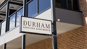 Un edificio de varios pisos con un cartel que dice 'Durham Serviced Apartments'.