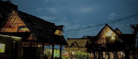 A traditional village with thatched-roof houses and a small market area.