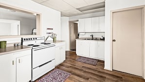 A kitchen with white cabinets, a stove, and a sink. - Superior Stay Very Cozy + Minutes to Duluth/Lake (Superior)