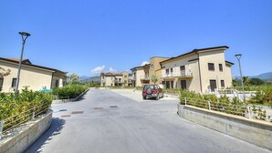 A residential street with modern houses, a parked car, and a clear blue sky. - Casa Ondina B: A welcoming apartment situated in a quiet location, a few minutes from the town center, with Free WI-FI. (Casal Velino)