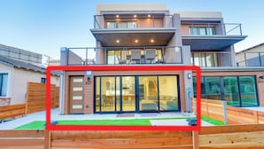 Een modern huis met twee verdiepingen, een balkon, grote schuifpuien en het zichtbare nummer 821.