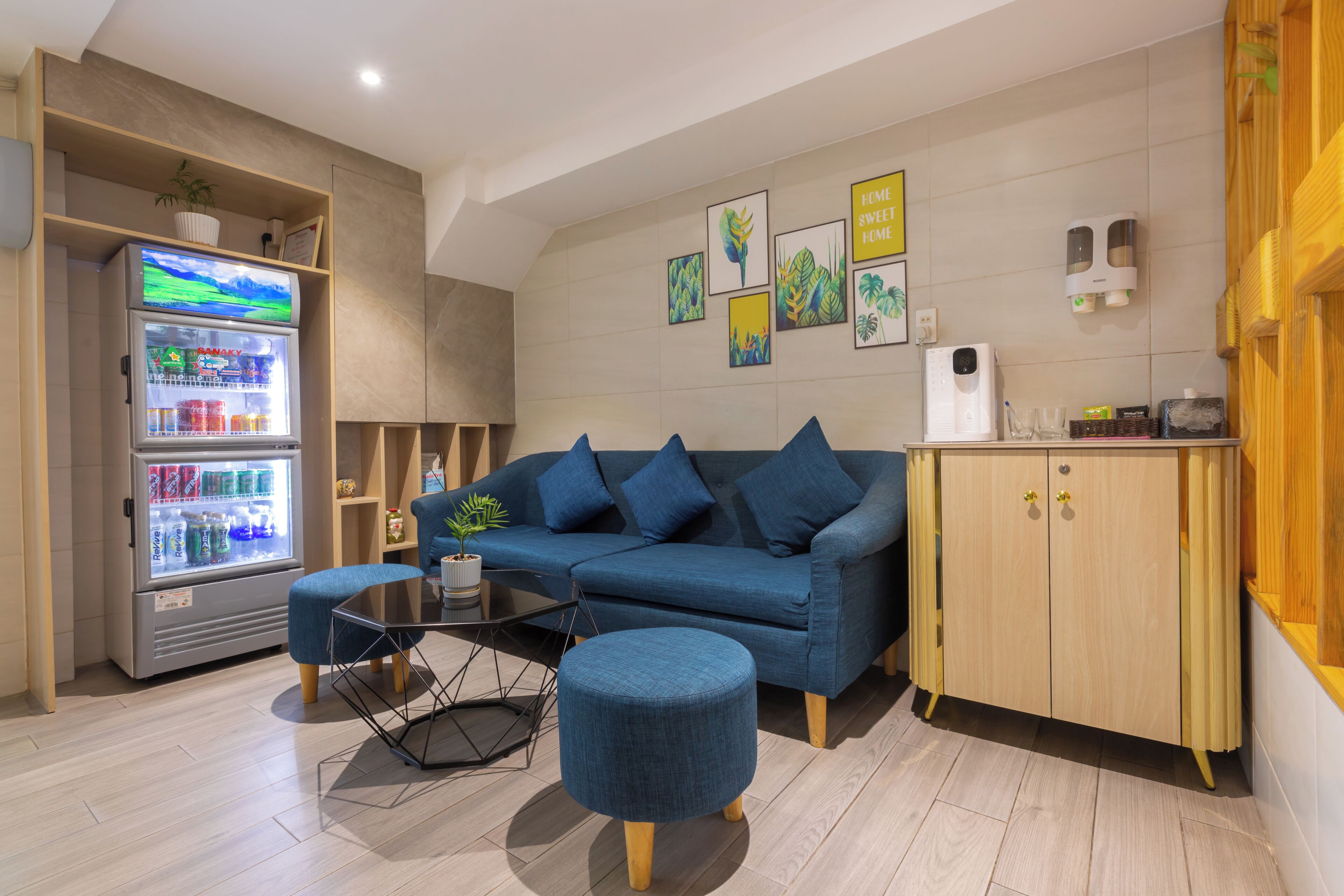 A modern living room with a blue sofa, a small coffee table, and a wooden cabinet.