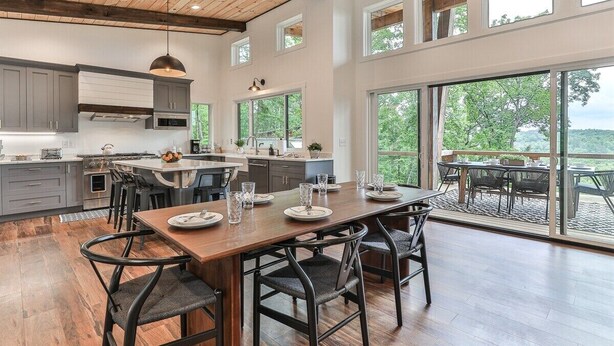 A spacious kitchen with a large island, modern appliances, and a dining area with a view. - The Cabin On Faraday | Ellijay, GA (Ellijay)