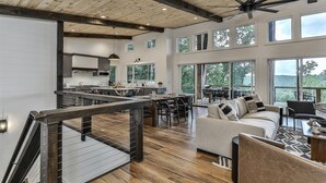 A spacious living area with a kitchen, dining area, and a staircase leading to an upper level. - The Cabin On Faraday | Ellijay, GA (Ellijay)