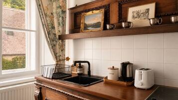 A kitchen with a wooden countertop, a coffee maker, a toaster, and a sink.