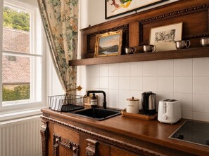 Una cocina con encimera de madera, cafetera, tostadora y fregadero.