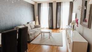 Una sala de estar moderna con un sofá, sillas, una mesa de centro y un aparador.