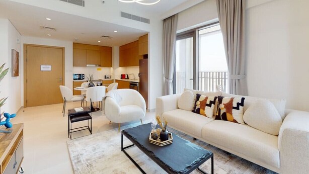 Una sala de estar moderna con un sofá, una mesa de centro y una zona de comedor con sillas y una mesa.
