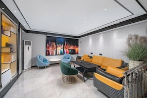 Uma sala de estar moderna com vista para a paisagem urbana, um sofá, cadeiras e uma mesa de centro.