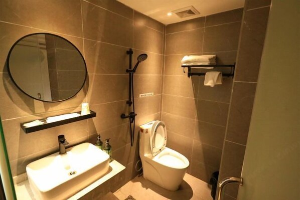 A bathroom with a sink, toilet, and shower. - Yinuo Hotel (Guangzhou Chenjiaci Caihongqiao Metro Station) (Guangzhou)