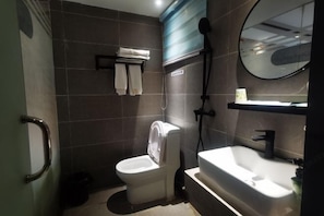 A bathroom with a toilet, a sink, and a shower. - Yinuo Hotel (Guangzhou Chenjiaci Caihongqiao Metro Station) (Guangzhou)
