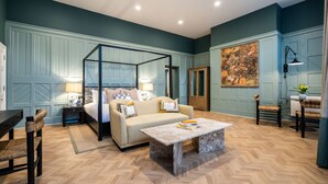 A room with a four-poster bed, a sofa, a coffee table, and a painting on the wall. - Old Abbey House Hotel (Abingdon)