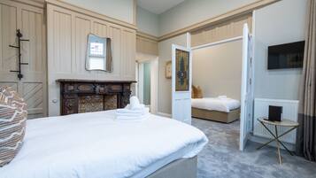 Una habitación de hotel con una cama grande, un aparador de madera, un espejo y un televisor en la pared.