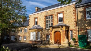 A traditional stone building with a central entrance, multiple windows, and a small garden area. - Old Abbey House Hotel (Abingdon)