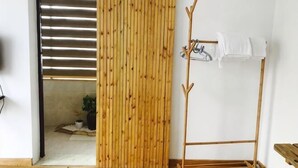 Una habitación con puerta corredera, perchero y una pequeña mesa.
