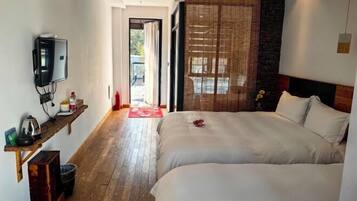 Une chambre d’hôtel avec un lit, une télévision, une étagère avec quelques objets et une vue sur l’extérieur.