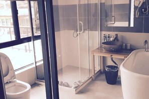 Un baño moderno con cabina de ducha de vidrio, inodoro, lavabo y bañera.