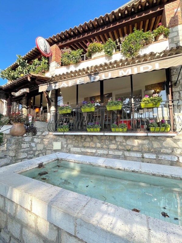 A café with outdoor seating, stone walls, and a tiled roof. - Le Loft de Borgada (Tourrettes-sur-Loup)