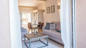 Ein gemütliches Wohnzimmer mit Sofa, Couchtisch und Essbereich mit Stühlen und Tisch.
