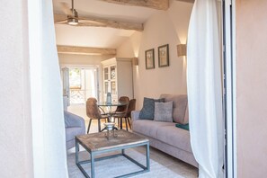 A cozy living room with a sofa, a coffee table, and a dining area with chairs and a table.