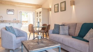 A modern living room with a sofa, armchairs, a coffee table, and a dining area with chairs and a table. - Le Loft de Borgada (Tourrettes-sur-Loup)