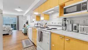 A modern kitchen with wooden cabinets, a white stove, and various appliances including a microwave and coffee maker. - 321 Getaway in Seattle Center-Belltown (Seattle)