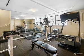 A gym with cardio machines, weight benches, and dumbbells. - 321 Getaway in Seattle Center-Belltown (Seattle)