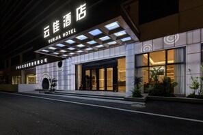 A hotel with a modern facade, large windows, and a sign indicating it is the Yun Jia Hotel.