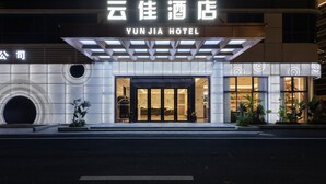 Exterior del Hotel Yun Jia con señalización iluminada, una entrada moderna y una fachada bien iluminada.