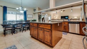 A spacious kitchen with a central island, wooden cabinets, and stainless steel appliances. - Havasu Cabana - Pool, Spa, Games, Lake View, Garage (Lake Havasu City)