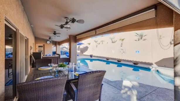 An outdoor dining area with a pool, ceiling fans, and a view of the pool. - Havasu Cabana - Pool, Spa, Games, Lake View, Garage (Lake Havasu City)
