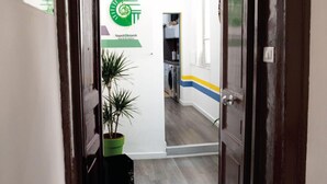 A hallway with a potted plant, a door with a number, and a sign with a logo. - Napoli Botanik Bed and Breakfast (Naples)