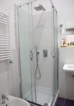 Habitación triple Confort, balcón, vistas a la ciudad | Baño | Ducha, artículos de higiene personal ecológicos y secador de pelo
