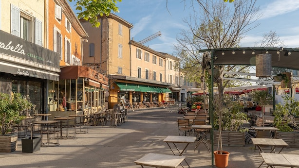 Een straat met terrasjes, een ijssalon en een café.