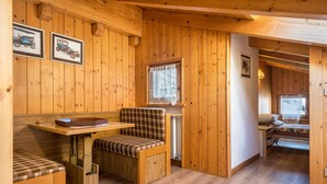 Un interior de madera con un banco, una mesa y una cama.