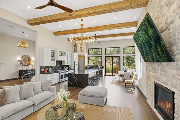 A spacious living area with a fireplace, a dining area, and a kitchen with a large island.