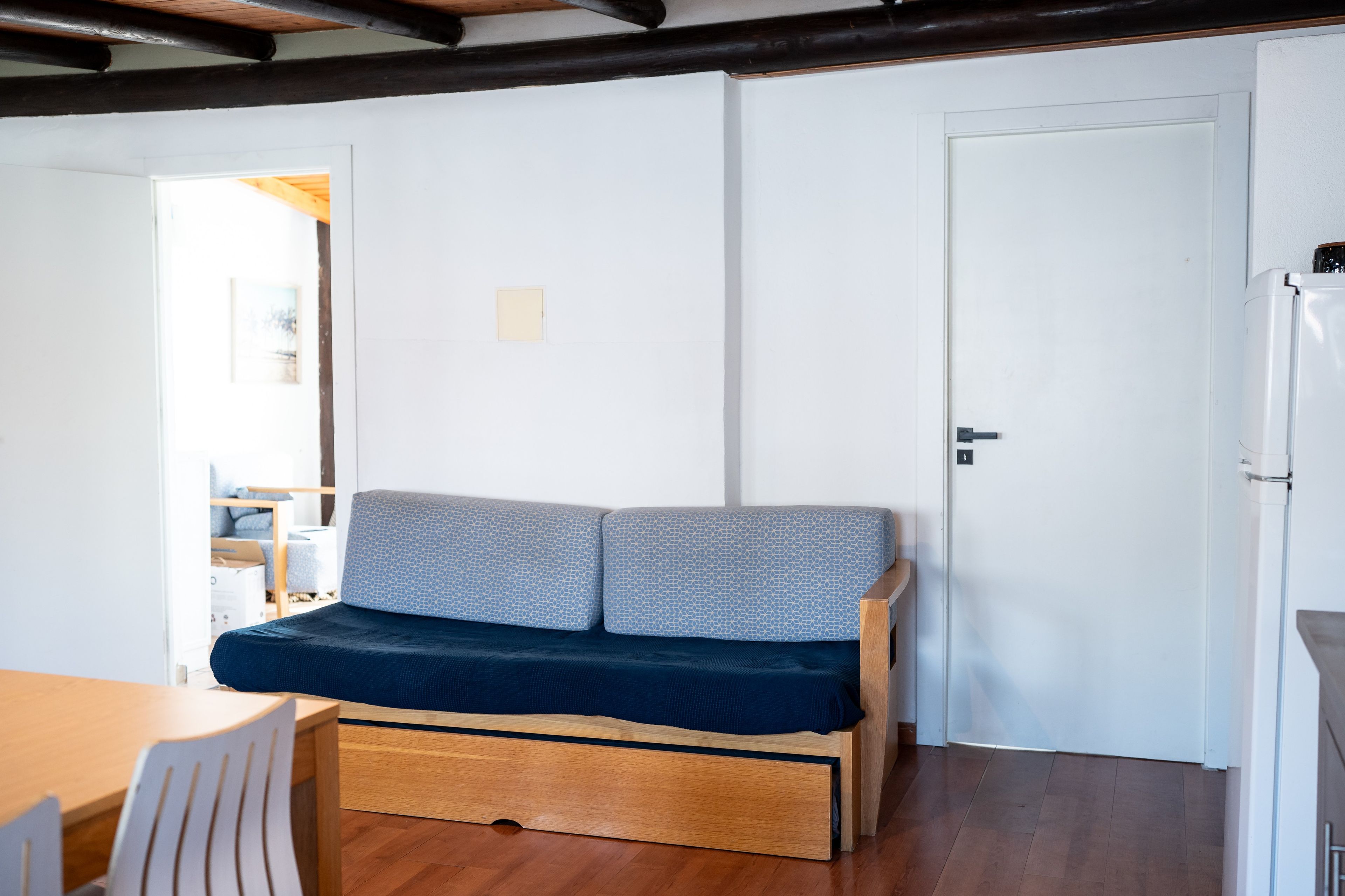 Un espacio habitable compacto con sofá, mesa de comedor y refrigerador.