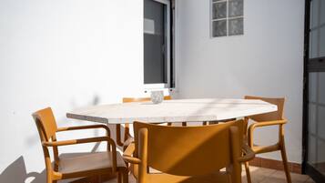 Una mesa redonda con seis sillas, una ventana y una puerta.