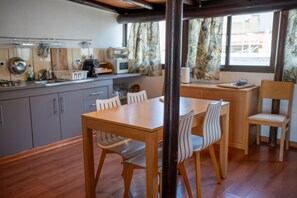 Une cuisine moderne avec des meubles en bois, une table à manger et des chaises.
